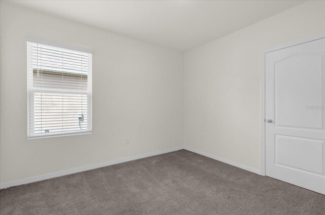 unfurnished room featuring carpet floors and baseboards