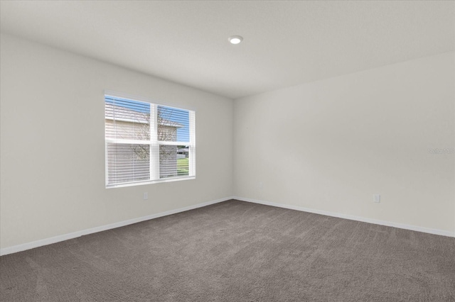 empty room featuring baseboards and carpet flooring