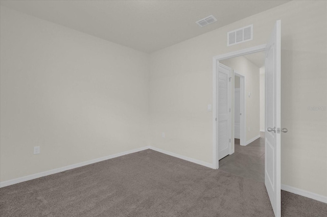 unfurnished room featuring carpet floors, visible vents, and baseboards