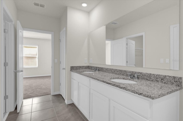 full bathroom featuring double vanity, a sink, visible vents, and tile patterned floors