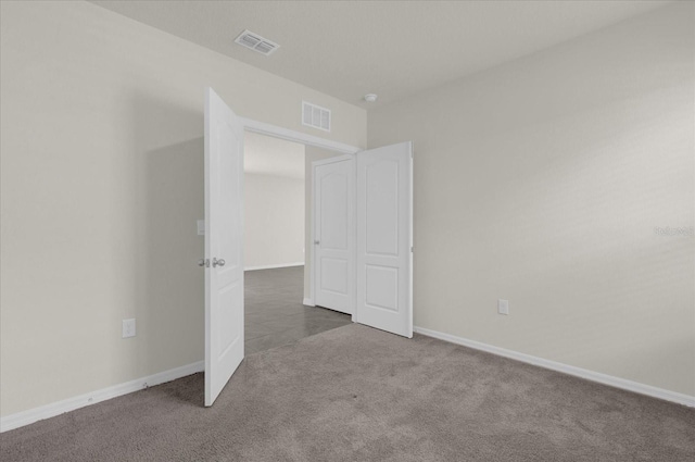 unfurnished bedroom featuring carpet floors, visible vents, and baseboards