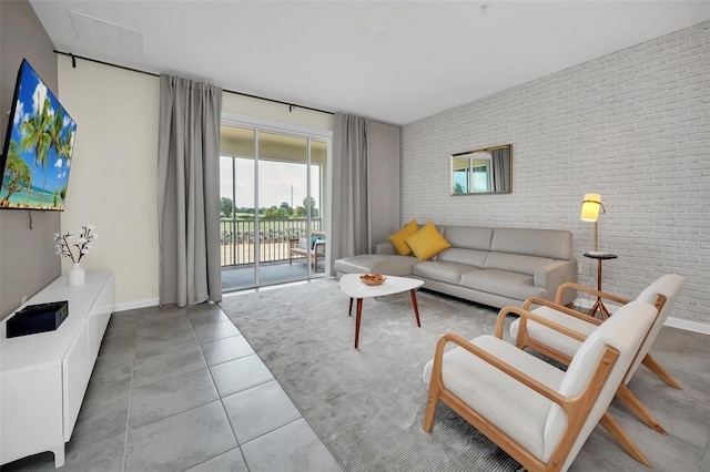 tiled living room featuring brick wall