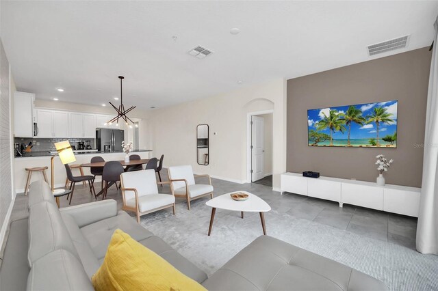 living room featuring a notable chandelier and light tile patterned floors