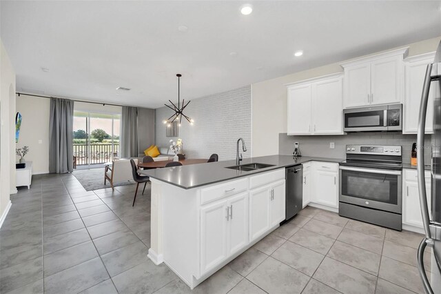 kitchen featuring appliances with stainless steel finishes, sink, kitchen peninsula, and light tile patterned floors