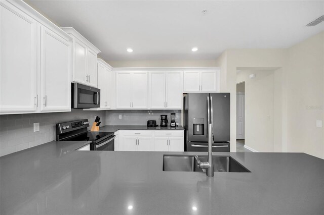 kitchen featuring white cabinetry, sink, stainless steel appliances, and backsplash