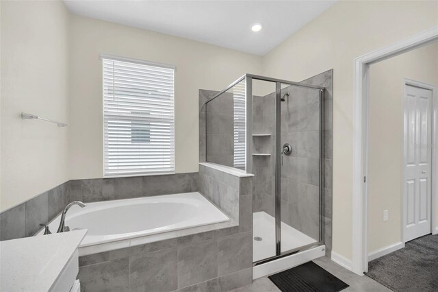 bathroom with shower with separate bathtub and plenty of natural light