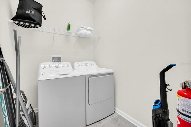 washroom featuring light tile patterned flooring and washing machine and dryer