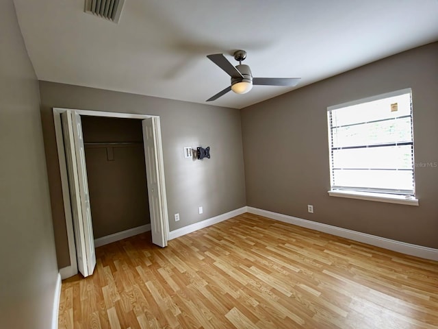 unfurnished bedroom featuring light wood-type flooring, ceiling fan, and a closet