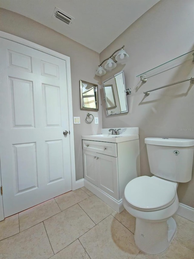 bathroom with tile patterned flooring, vanity, and toilet