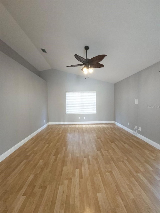 empty room featuring light wood-type flooring, vaulted ceiling, and ceiling fan