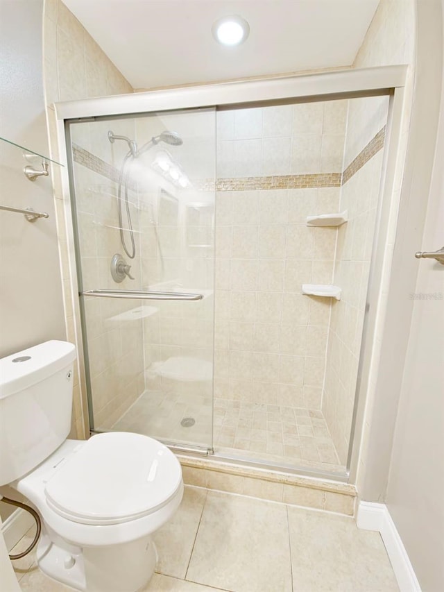 bathroom featuring walk in shower, toilet, and tile patterned floors