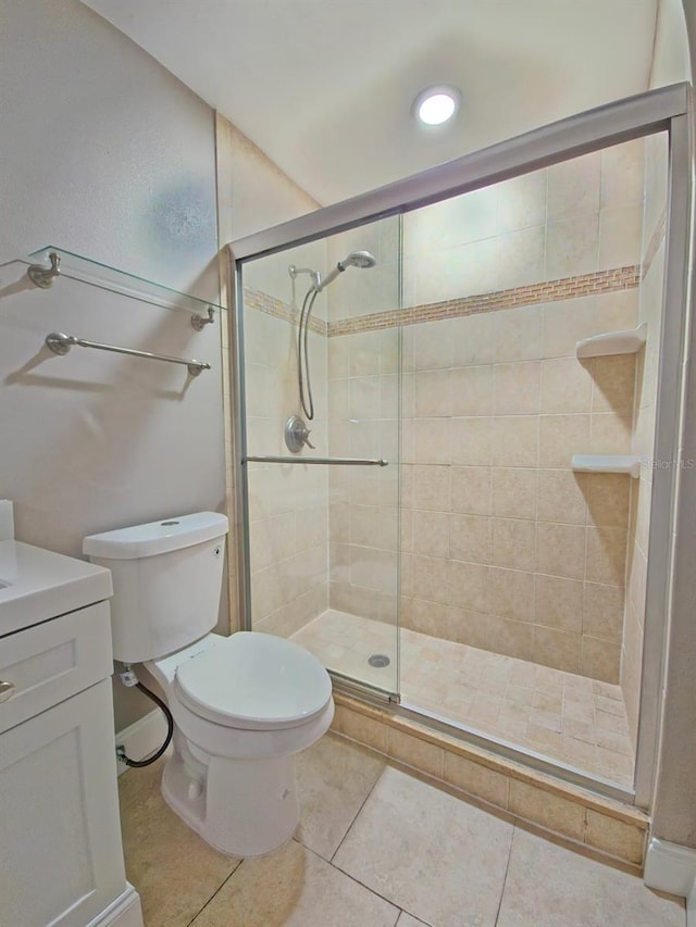 bathroom with vanity, tile patterned floors, a shower with shower door, and toilet