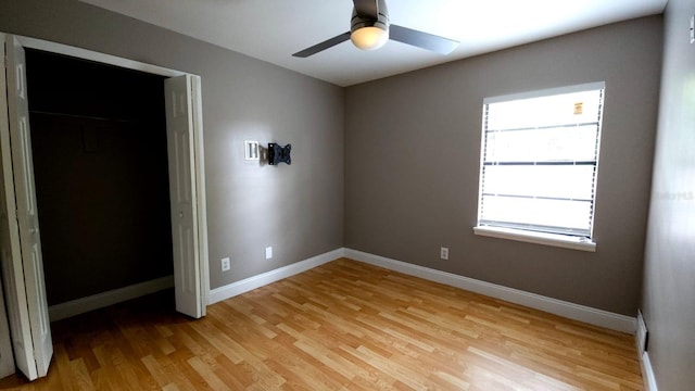 unfurnished bedroom featuring ceiling fan, a closet, and light hardwood / wood-style floors