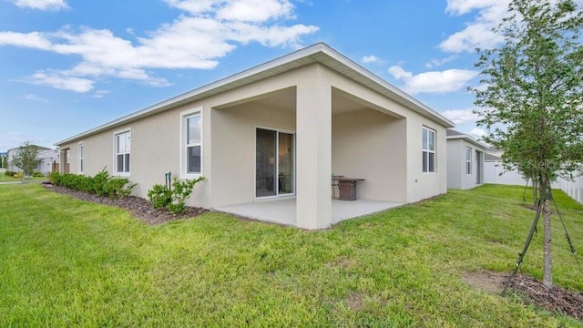 rear view of house featuring a yard and a patio area