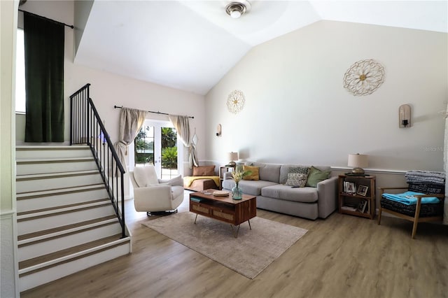 living room featuring lofted ceiling, wood-type flooring, and french doors