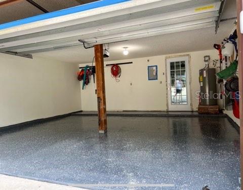 garage featuring a garage door opener and water heater