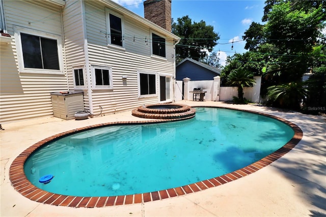 view of pool featuring an in ground hot tub, a patio, and grilling area