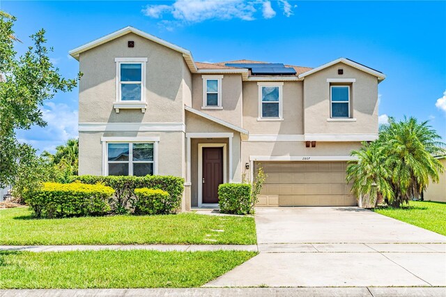 view of front facade featuring a garage, solar panels, and a front yard