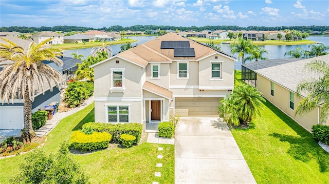 view of front of house featuring a front yard, solar panels, a garage, and a water view