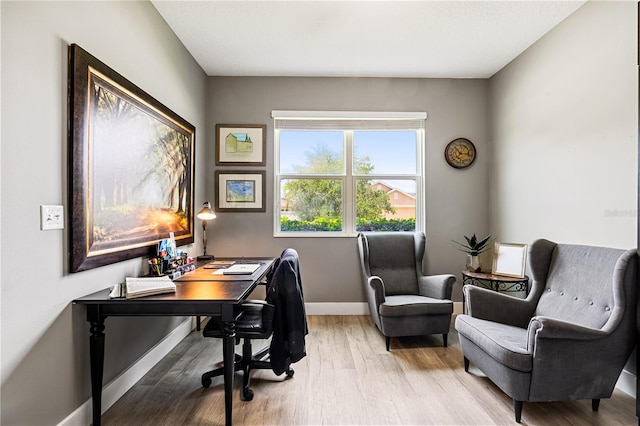 home office with light hardwood / wood-style flooring