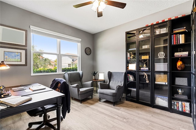 office with light hardwood / wood-style flooring and ceiling fan