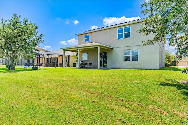 rear view of house featuring a patio area and a yard