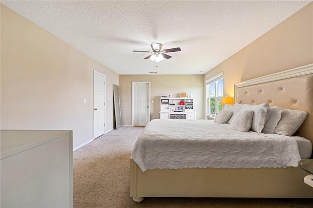 carpeted bedroom with ceiling fan and a textured ceiling