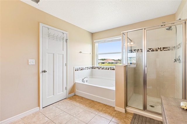 bathroom with tile patterned floors, independent shower and bath, and a textured ceiling