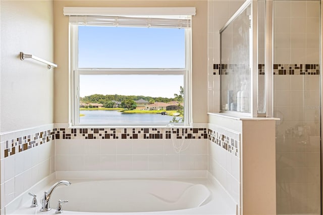 bathroom featuring a bathtub and a water view