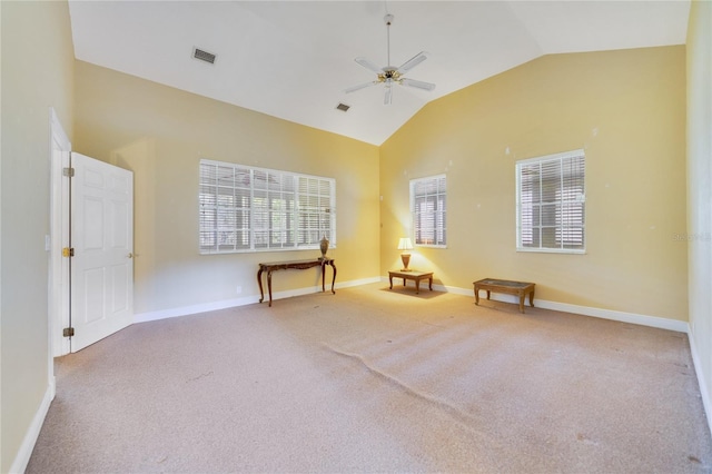 empty room featuring light colored carpet, visible vents, ceiling fan, high vaulted ceiling, and baseboards