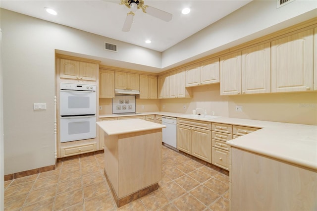 kitchen with under cabinet range hood, white appliances, visible vents, light countertops, and a center island