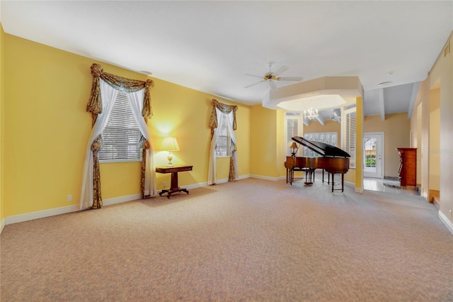 sitting room featuring ceiling fan with notable chandelier, carpet flooring, and baseboards