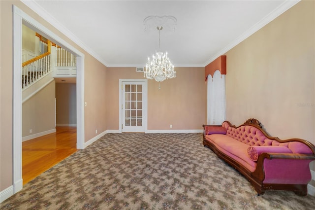 living area with carpet flooring, a notable chandelier, crown molding, and baseboards