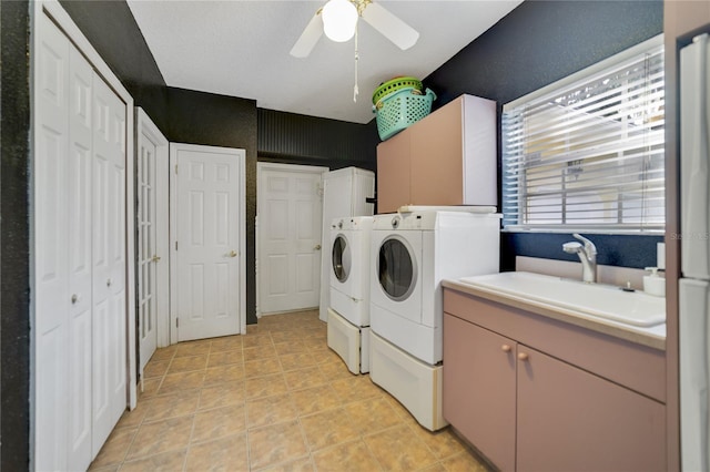 laundry area with ceiling fan, light tile patterned flooring, a sink, independent washer and dryer, and cabinet space