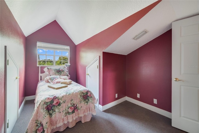 bedroom with baseboards, visible vents, vaulted ceiling, and dark colored carpet