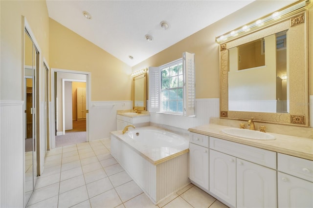 full bath featuring tile patterned flooring, vaulted ceiling, a wainscoted wall, and a sink