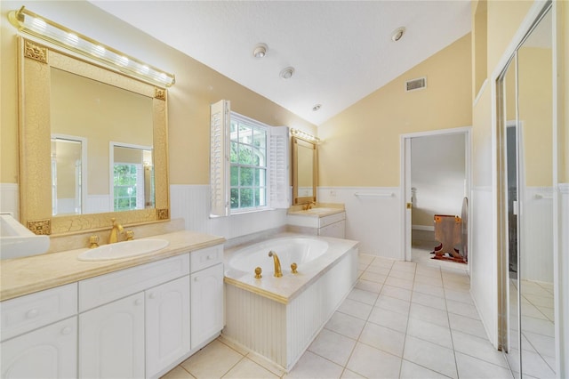 bathroom featuring visible vents, wainscoting, vaulted ceiling, vanity, and tile patterned flooring