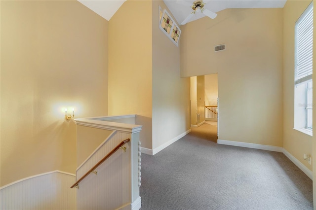 hallway with visible vents, carpet, an upstairs landing, and baseboards