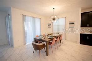 dining room with light tile patterned flooring and a chandelier