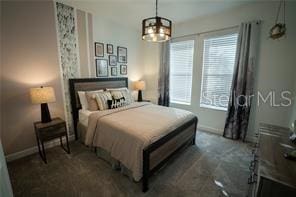 bedroom featuring a notable chandelier and multiple windows