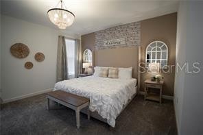 carpeted bedroom featuring a notable chandelier