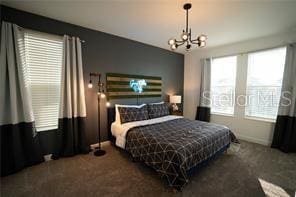 carpeted bedroom featuring an inviting chandelier