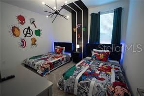 carpeted bedroom featuring an inviting chandelier