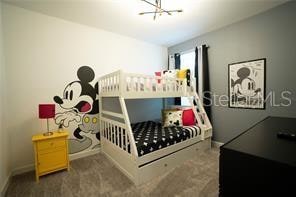 carpeted bedroom featuring a notable chandelier