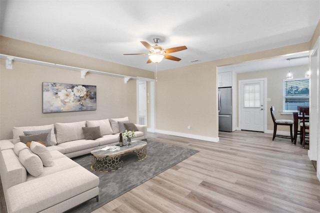 living room featuring ceiling fan and light hardwood / wood-style flooring