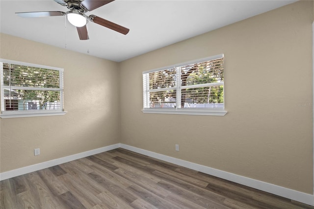 empty room with hardwood / wood-style floors and ceiling fan