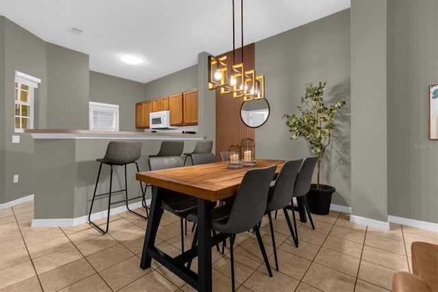 tiled dining room featuring a chandelier