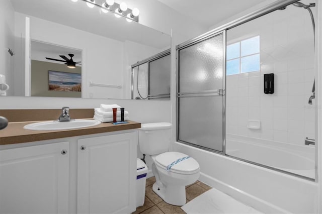 full bathroom with ceiling fan, toilet, tile patterned flooring, vanity, and shower / bath combination with glass door