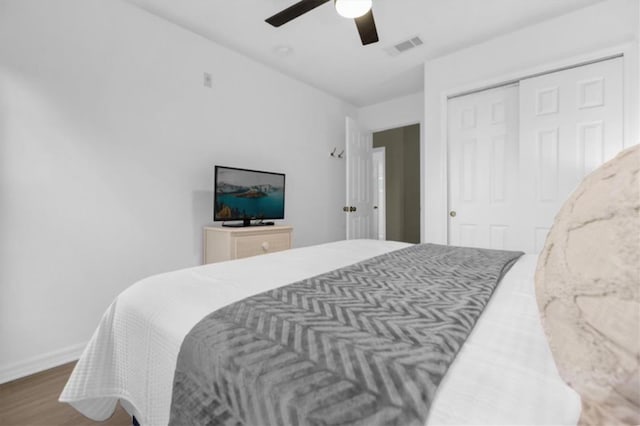 bedroom featuring hardwood / wood-style floors, ceiling fan, and a closet