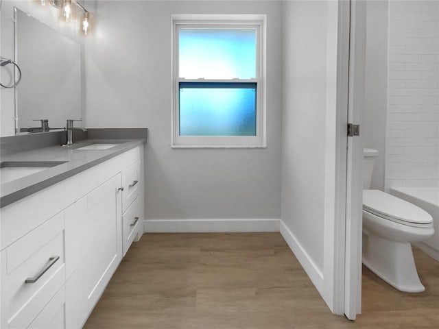 full bathroom featuring vanity,  shower combination, toilet, and hardwood / wood-style floors